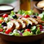Fresh and flavorful Greek Chicken Salad with grilled chicken, crisp vegetables, feta cheese, and a tangy dressing in a rustic bowl.